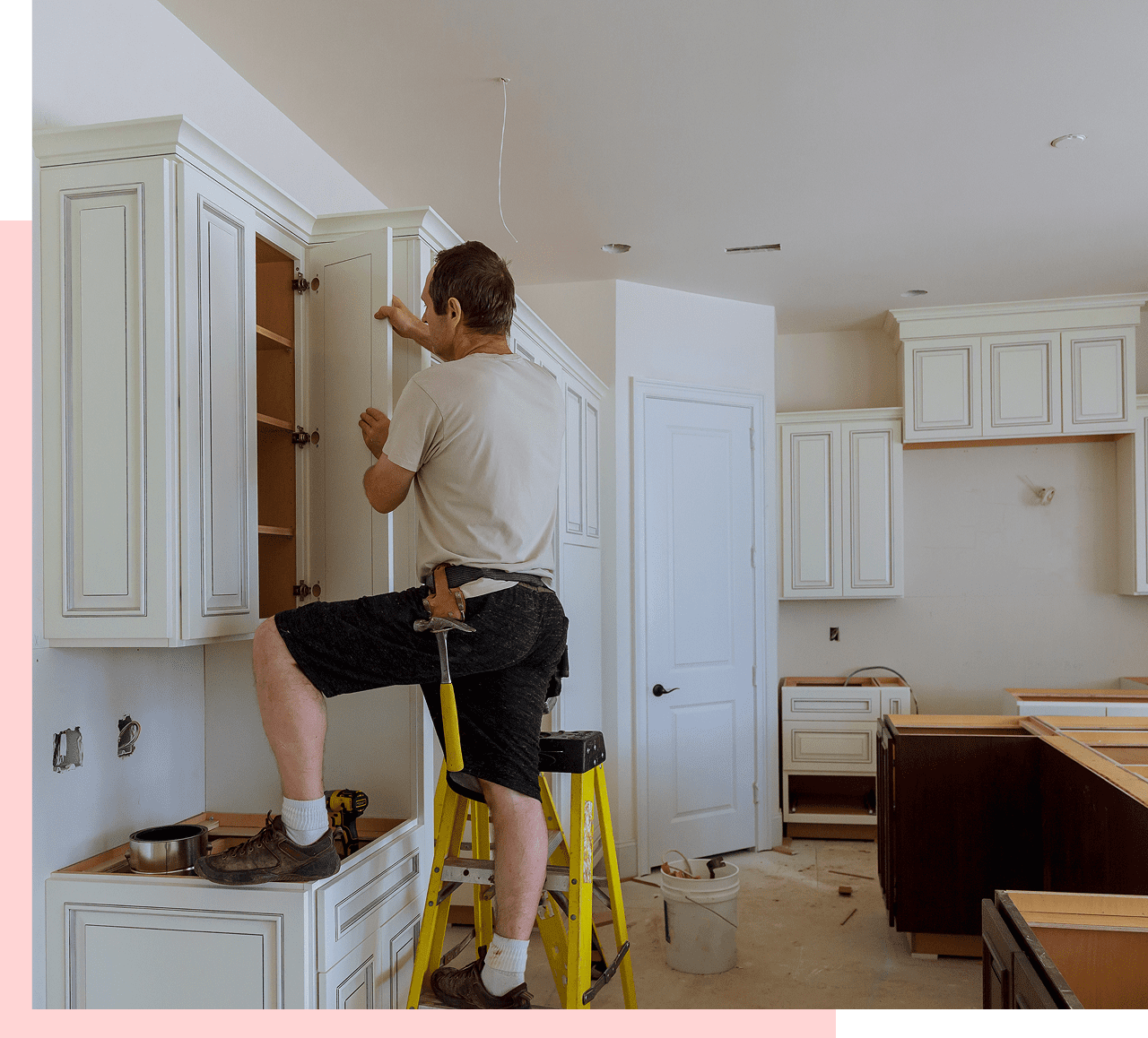 Group 1321317247 Man installing cabinets in a kitchen.