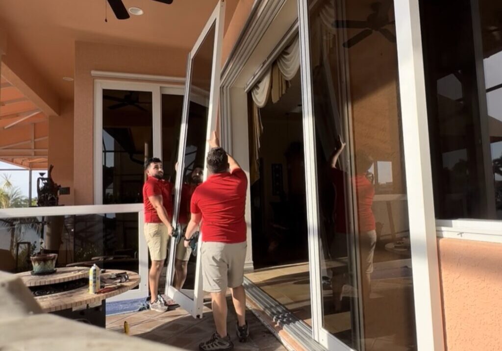 tempImagefSGdfF Two men installing large glass door.